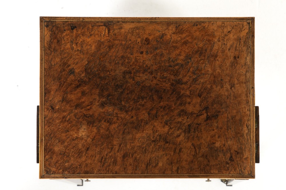 A small 19th-century burr yew wood writing table featuring a single drawer, two pull-out side slides, a lower undershelf, inlaid stringing, tapered legs, and brass casters. View VI