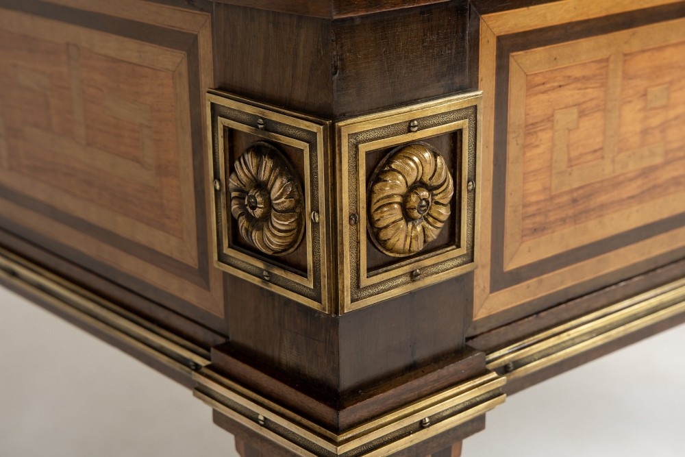 A 19th-century French Louis XVI style bureau plat writing desk featuring geometric parquetry inlay, three frieze drawers, a leather top insert, and brass mounts on square tapered legs. View VI