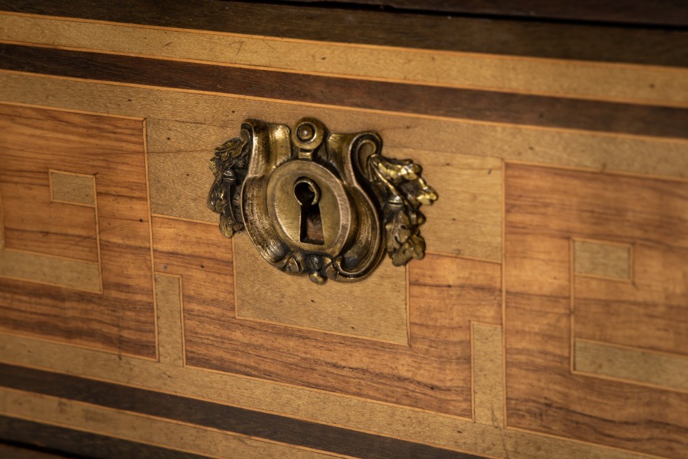 A 19th-century French Louis XVI style bureau plat writing desk featuring geometric parquetry inlay, three frieze drawers, a leather top insert, and brass mounts on square tapered legs. View XII
