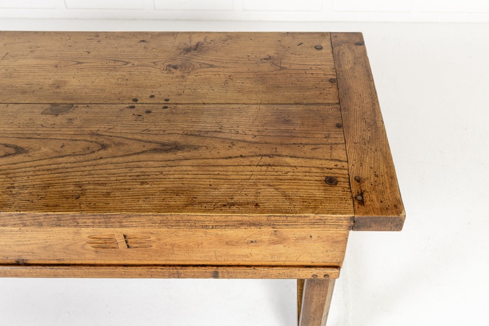 A long, rectangular 18th-century French oak table featuring two drawers with carved recessed pulls and lower stretchers connecting the legs. View VI