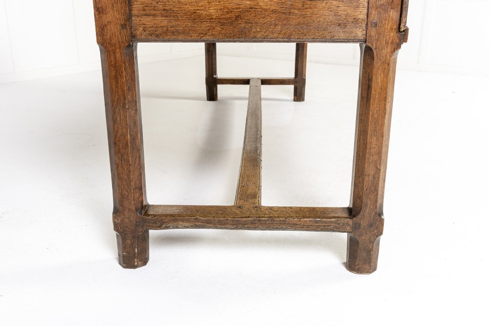 A long, rectangular 18th-century French oak table featuring two drawers with carved recessed pulls and lower stretchers connecting the legs. View XI