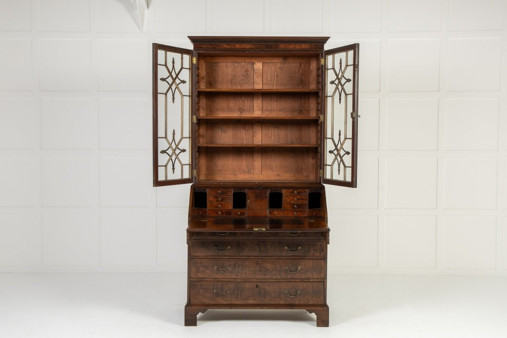 An 18th-century Georgian mahogany bureau bookcase featuring a twin-door upper cabinet with astragal glazing bars over a slant-front writing slope and four graduated drawers on bracket feet. View IV
