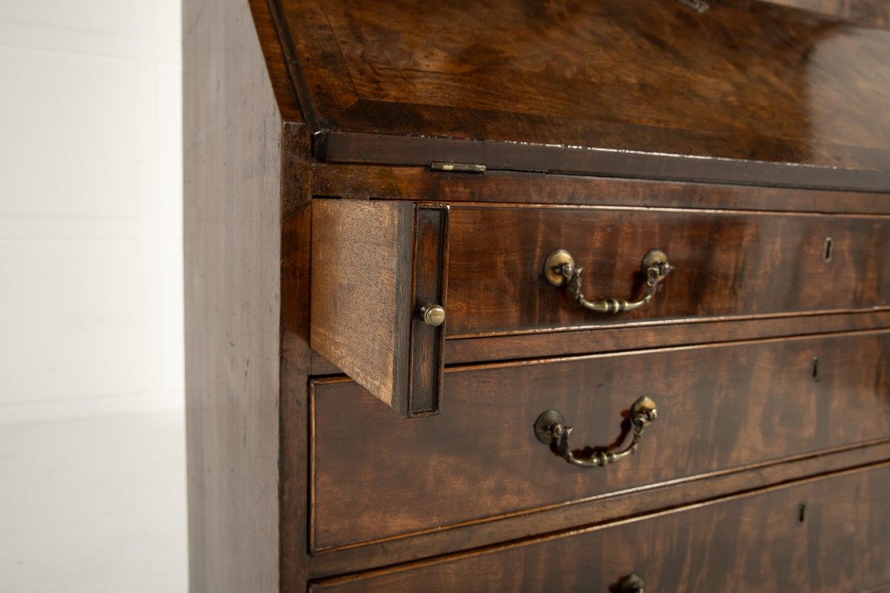 An 18th-century Georgian mahogany bureau bookcase featuring a twin-door upper cabinet with astragal glazing bars over a slant-front writing slope and four graduated drawers on bracket feet. View IX