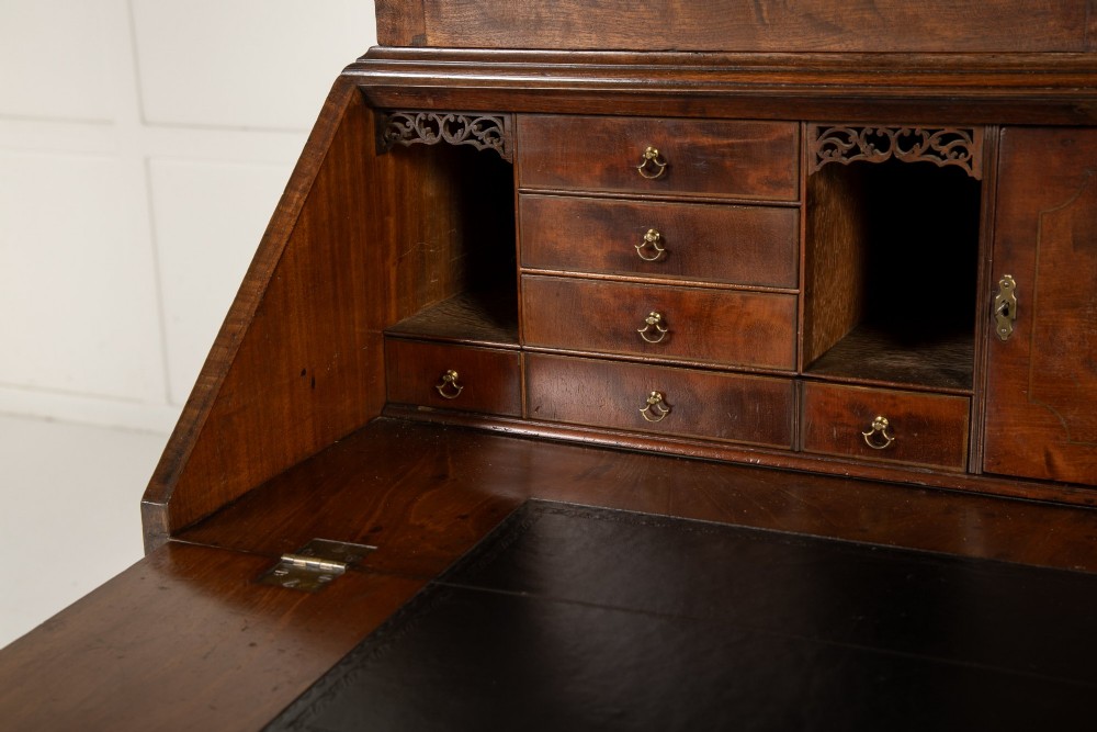 An 18th-century Georgian mahogany bureau bookcase featuring a twin-door upper cabinet with astragal glazing bars over a slant-front writing slope and four graduated drawers on bracket feet. View X