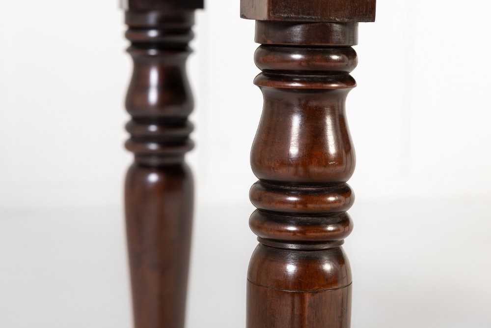 A 19th-century Regency mahogany serving table featuring a pointed splashback upstand, decorative carved frieze, turned front legs, and carved lion paw feet. View IV