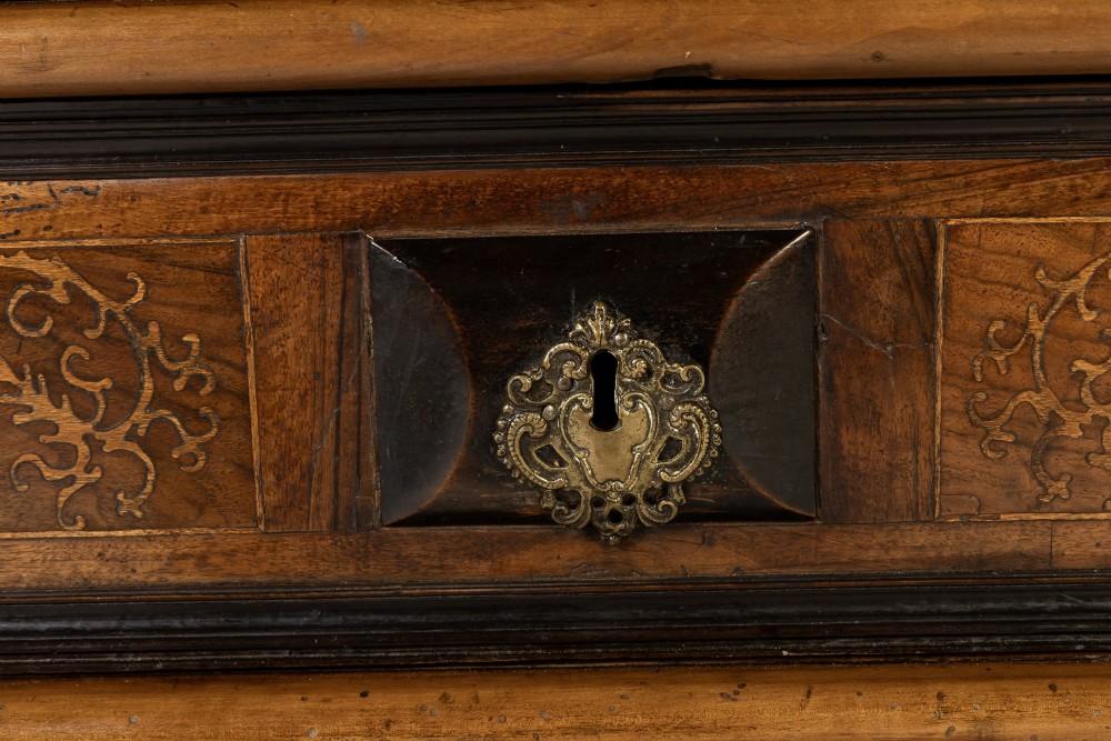 An 18th-century Italian walnut chest of drawers featuring foliage marquetry, brass drop handles, and geometric side moulding. View IV