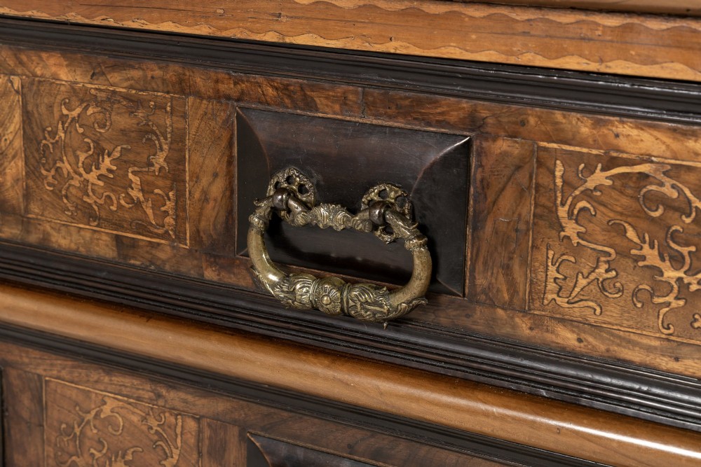 An 18th-century Italian walnut chest of drawers featuring foliage marquetry, brass drop handles, and geometric side moulding. View VIII
