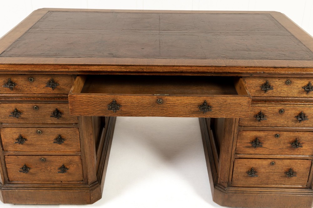 A large 19th-century English oak partners desk with twin pedestals, multiple drawers, metal drop handles, and panelled sides. View VI