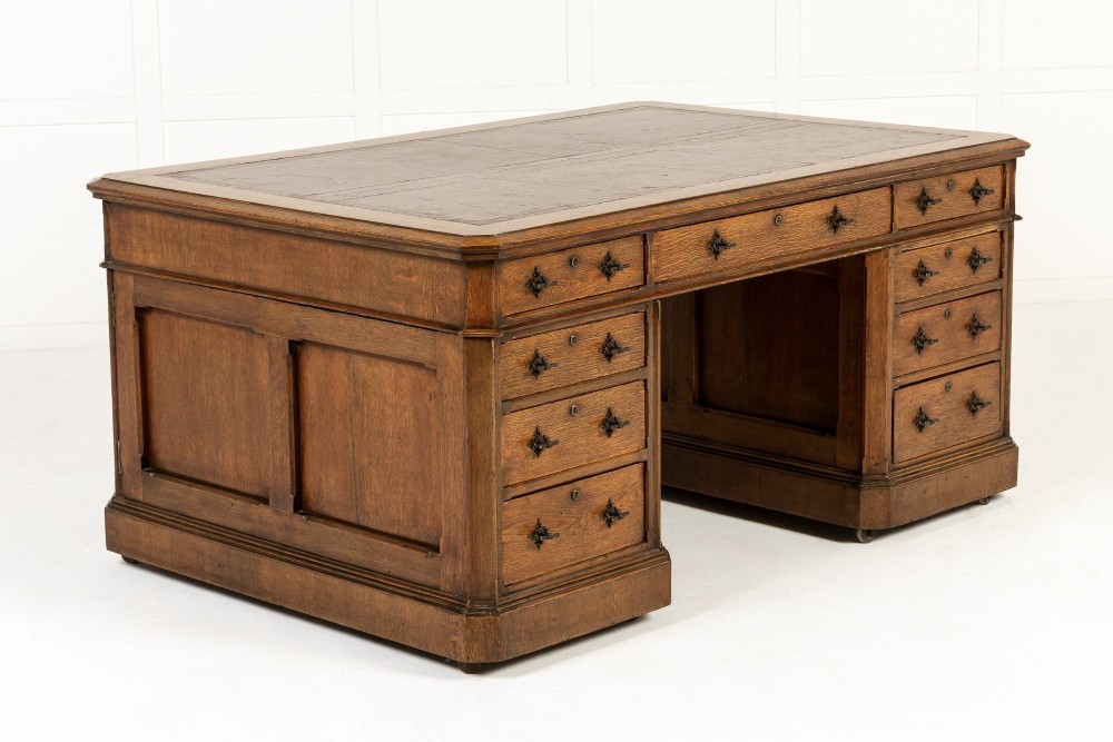 A large 19th-century English oak partners desk with twin pedestals, multiple drawers, metal drop handles, and panelled sides. View VIII