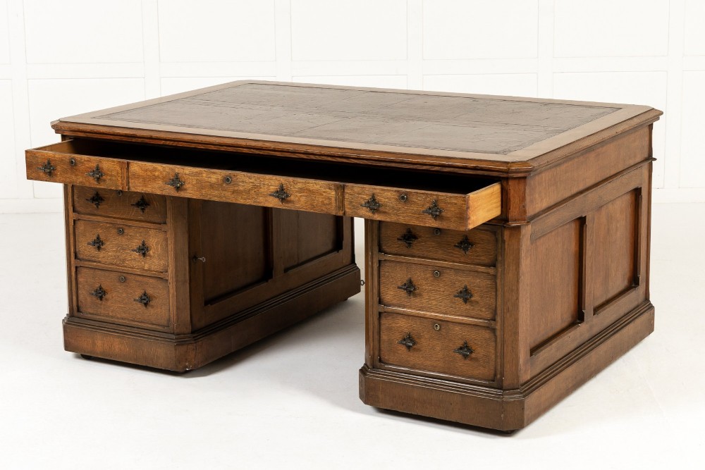 A large 19th-century English oak partners desk with twin pedestals, multiple drawers, metal drop handles, and panelled sides. View IX