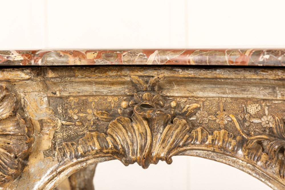 An 18th-century Italian Rococo console table featuring carved silver gilt legs with central shell motifs and a contoured variegated marble top. View III