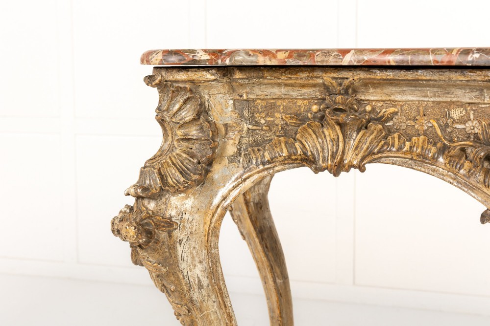 An 18th-century Italian Rococo console table featuring carved silver gilt legs with central shell motifs and a contoured variegated marble top. View IV