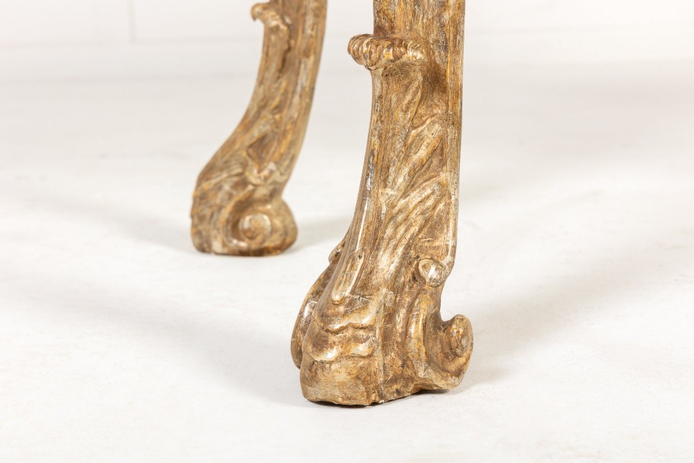 An 18th-century Italian Rococo console table featuring carved silver gilt legs with central shell motifs and a contoured variegated marble top. View V