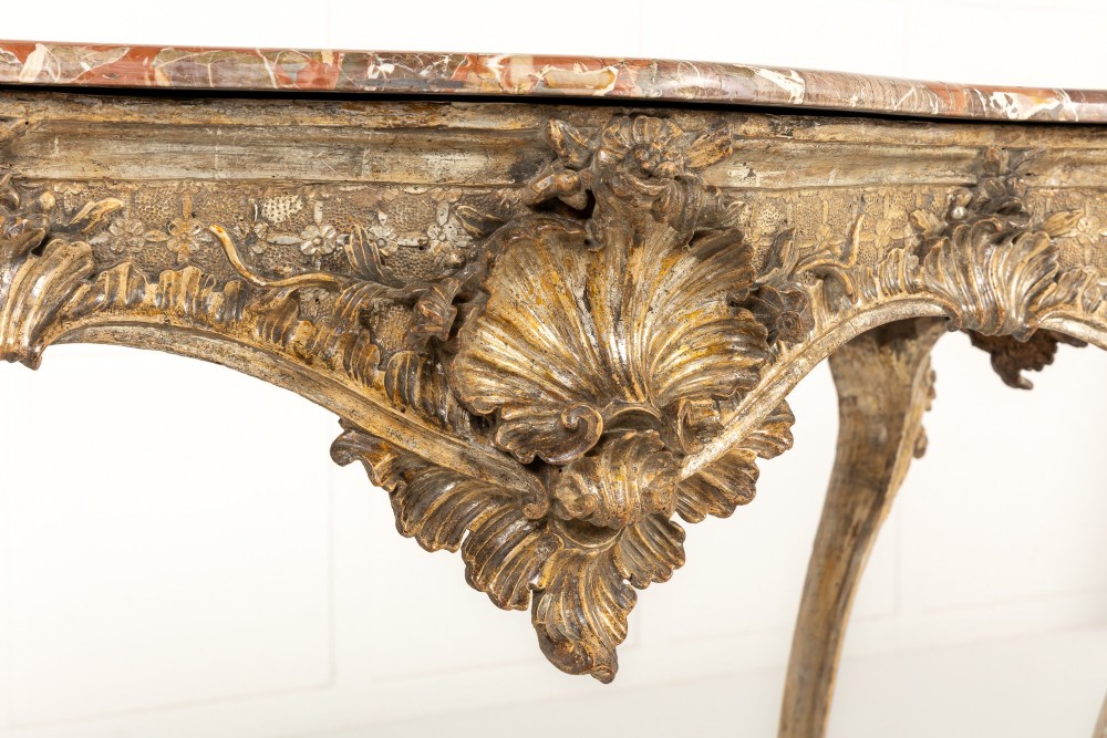 An 18th-century Italian Rococo console table featuring carved silver gilt legs with central shell motifs and a contoured variegated marble top. View VI