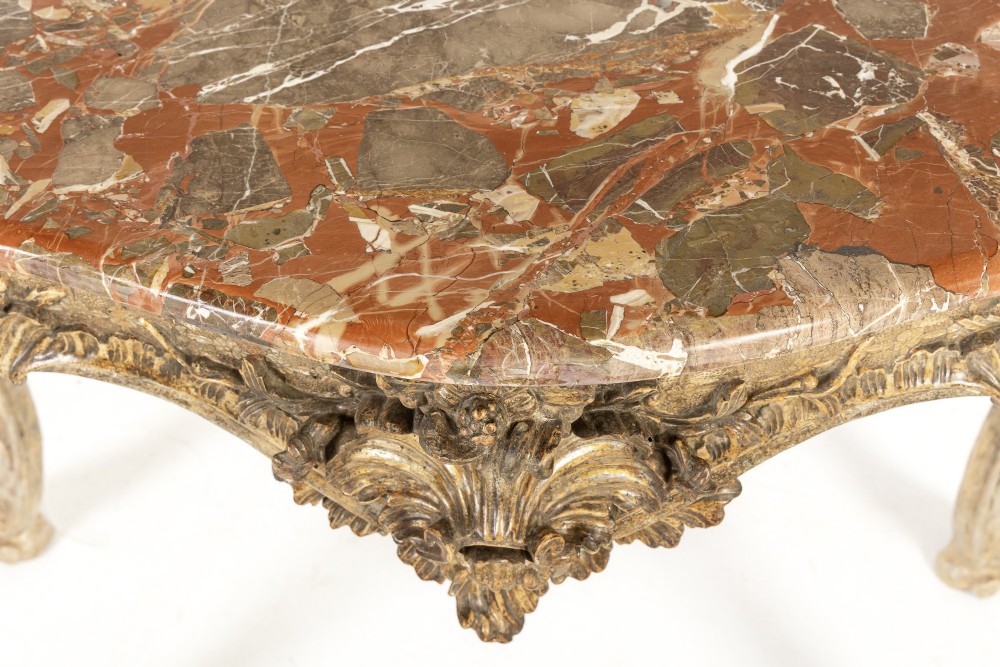 An 18th-century Italian Rococo console table featuring carved silver gilt legs with central shell motifs and a contoured variegated marble top. View VIII