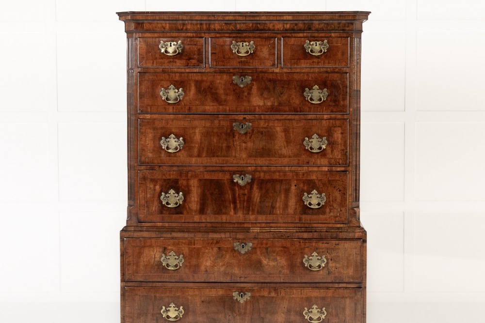 An 18th-century English walnut chest on chest featuring stacked drawers, figured timber veneers, brass backplate handles, and bracket feet. View II