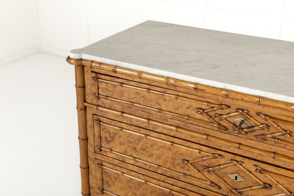 A nineteenth-century French birds eye maple commode featuring carved faux bamboo mouldings, four drawers, and a white marble top. View II