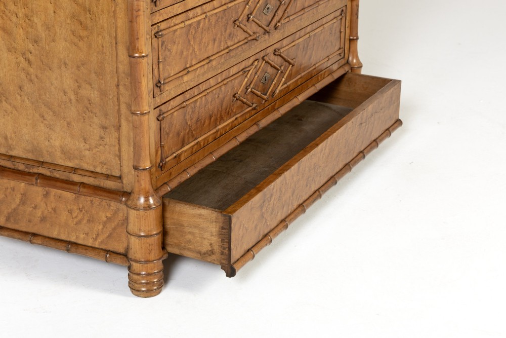 A nineteenth-century French birds eye maple commode featuring carved faux bamboo mouldings, four drawers, and a white marble top. View VI
