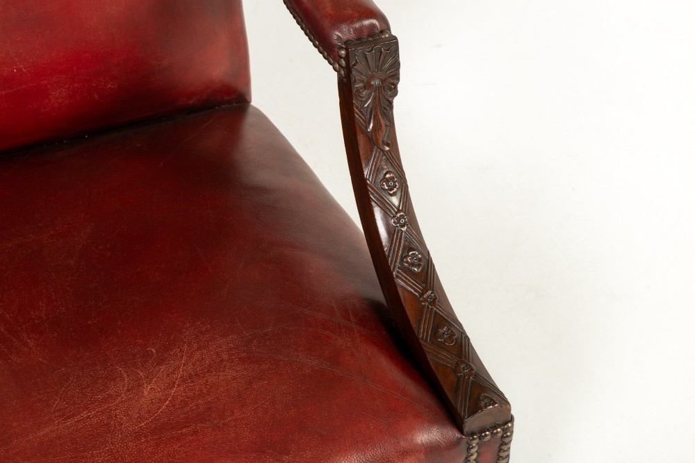 An 18th-century English Gainsborough armchair featuring deep red leather upholstery with brass studding, carved mahogany arms, and square legs. View III