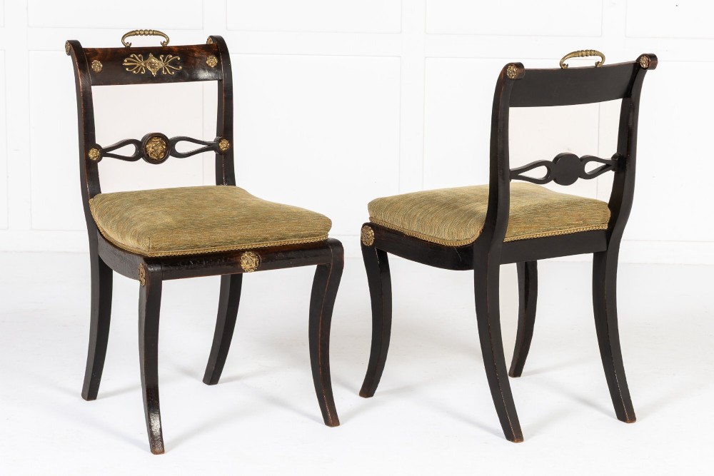 A set of six early nineteenth-century Regency dining chairs crafted from dark wood with brass inlay detailing, brass top handles, and green upholstered seats. View II
