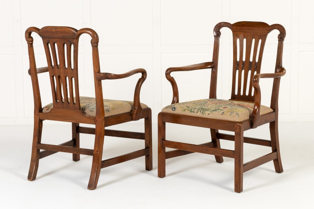 A pair of 18th-century George III mahogany armchairs featuring carved crest rails, vertical slatted splats, curved armrests, and needlepoint upholstered seats. View II