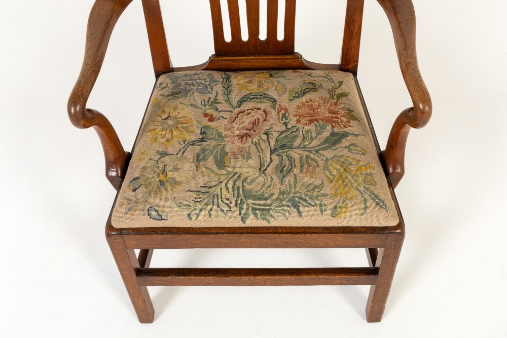 A pair of 18th-century George III mahogany armchairs featuring carved crest rails, vertical slatted splats, curved armrests, and needlepoint upholstered seats. View III