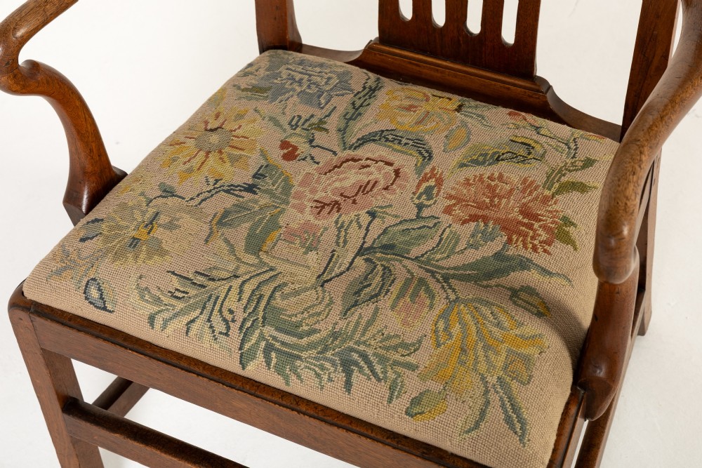 A pair of 18th-century George III mahogany armchairs featuring carved crest rails, vertical slatted splats, curved armrests, and needlepoint upholstered seats. View IV