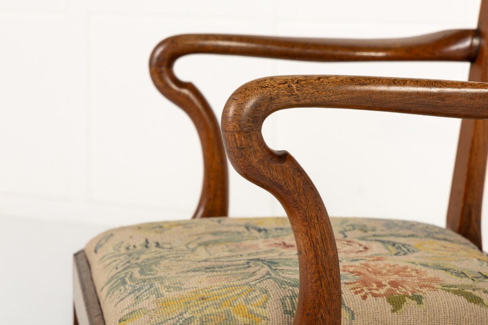 A pair of 18th-century George III mahogany armchairs featuring carved crest rails, vertical slatted splats, curved armrests, and needlepoint upholstered seats. View V