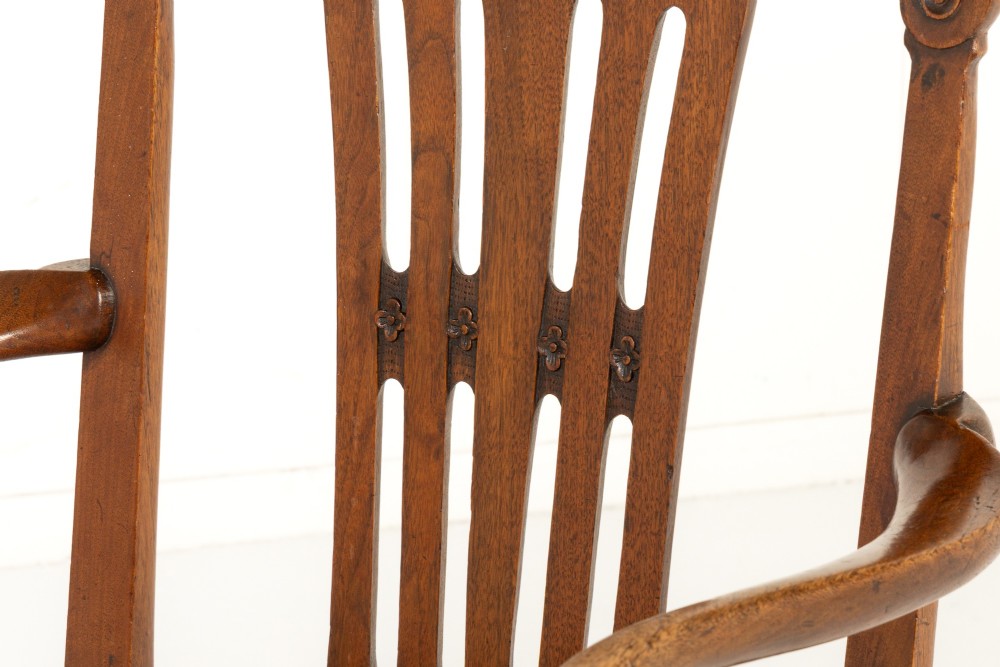 A pair of 18th-century George III mahogany armchairs featuring carved crest rails, vertical slatted splats, curved armrests, and needlepoint upholstered seats. View VI