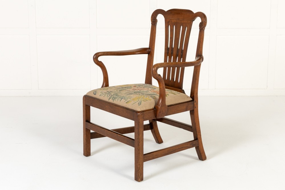 A pair of 18th-century George III mahogany armchairs featuring carved crest rails, vertical slatted splats, curved armrests, and needlepoint upholstered seats. View VIII