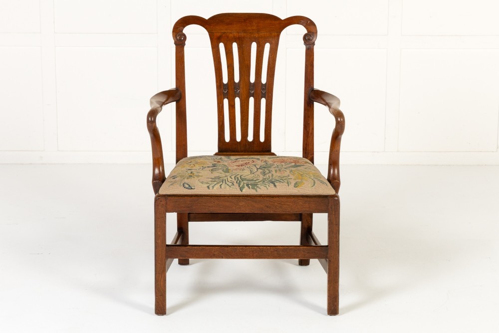A pair of 18th-century George III mahogany armchairs featuring carved crest rails, vertical slatted splats, curved armrests, and needlepoint upholstered seats. View IX