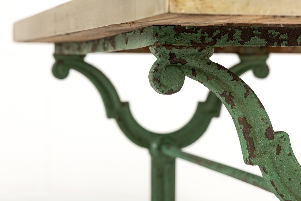 A pair of 19th-century bistro tables featuring rectangular grey veined marble tops framed in brass above weathered green-painted cast iron bases. View V