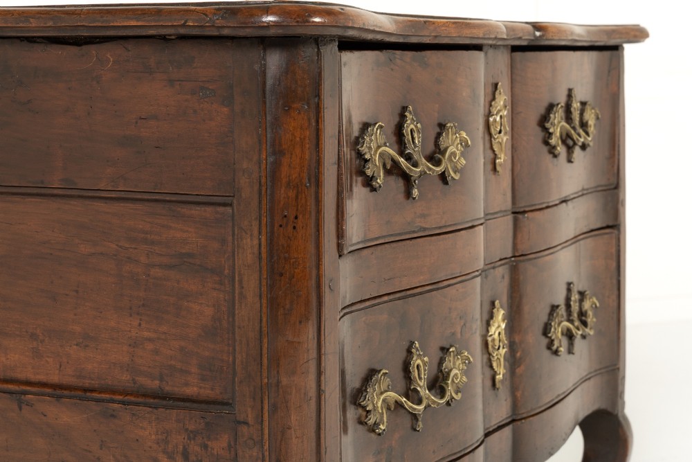 An 18th-century French walnut commode featuring two drawers with cast brass handles, a serpentine front, and cabriole legs. View III