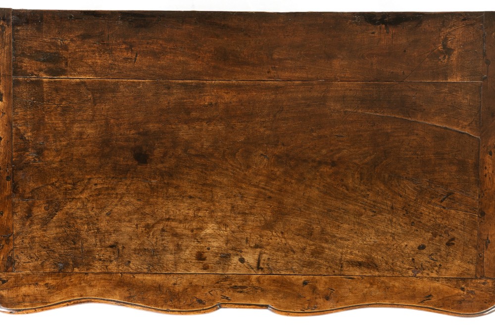 An 18th-century French walnut commode featuring two drawers with cast brass handles, a serpentine front, and cabriole legs. View V