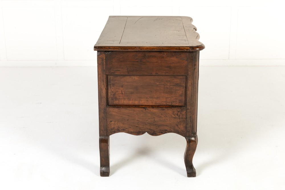 An 18th-century French walnut commode featuring two drawers with cast brass handles, a serpentine front, and cabriole legs. View VII