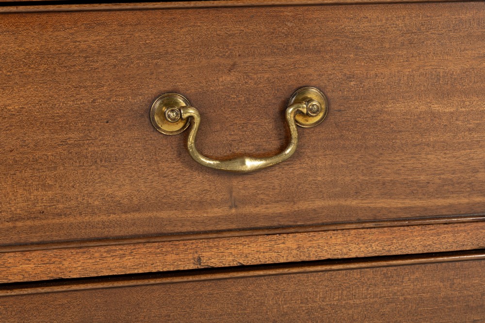 An 18th-century George III mahogany chest of drawers featuring two short over three long graduated drawers with brass swan-neck handles and bracket feet. View IV