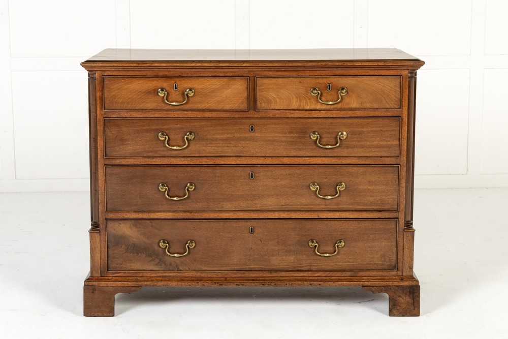 An 18th-century George III mahogany chest of drawers featuring two short over three long graduated drawers with brass swan-neck handles and bracket feet. View IX