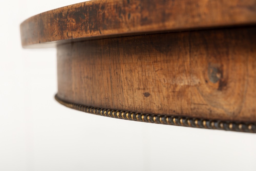 A nineteenth-century Regency circular centre table made of rosewood with a quadripod pedestal base on brass castors. View V