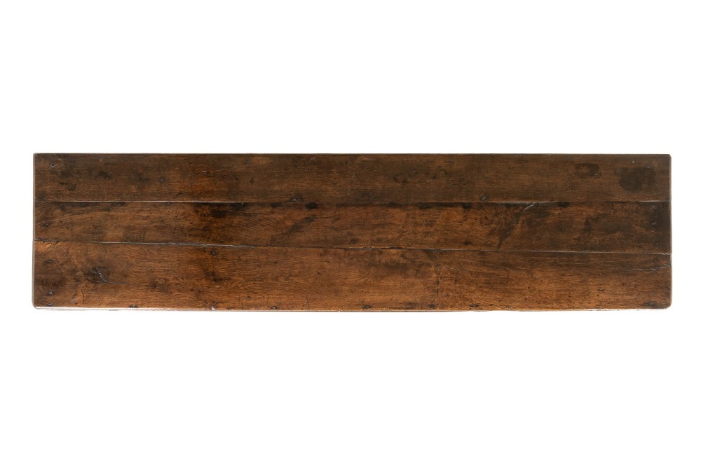 An 18th-century dark oak dresser base featuring geometric panelled drawer fronts, a shaped lower apron, turned front legs, and a bottom potboard shelf. View X