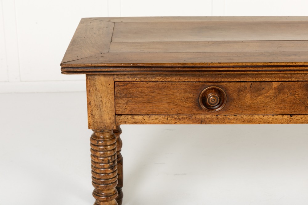 A 19th-century French walnut drapers table with three drawers, wooden knobs, a central keyhole, and turned legs with lower stretchers. View II