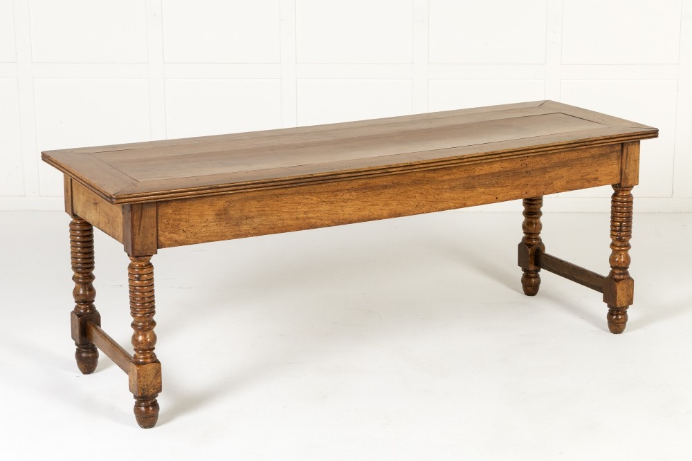 A 19th-century French walnut drapers table with three drawers, wooden knobs, a central keyhole, and turned legs with lower stretchers. View VIII