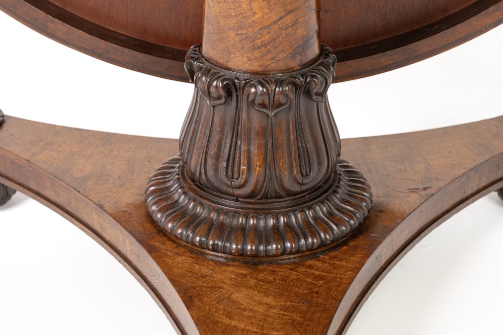 An early nineteenth-century circular centre table featuring a figured burr oak top mounted on a carved central column and a tri-form base with carved feet. View IV