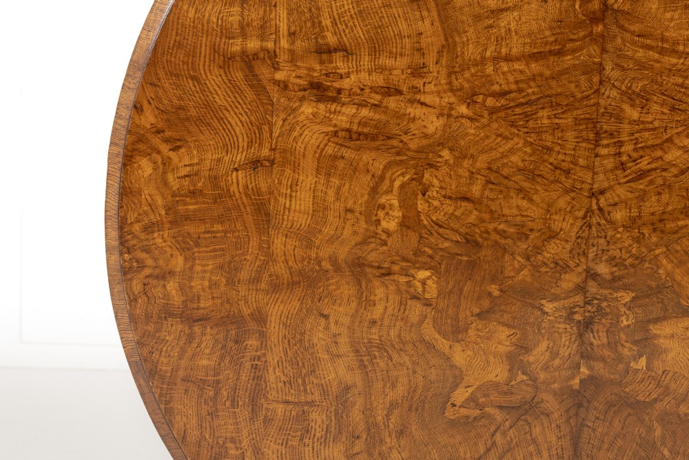 An early nineteenth-century circular centre table featuring a figured burr oak top mounted on a carved central column and a tri-form base with carved feet. View VI
