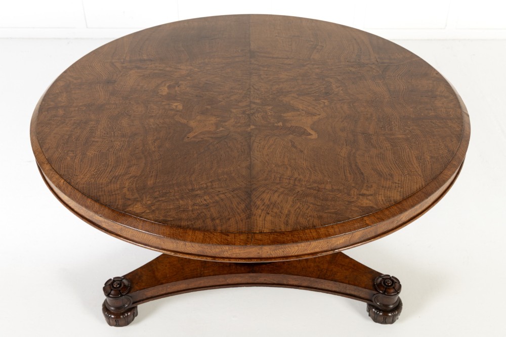 An early nineteenth-century circular centre table featuring a figured burr oak top mounted on a carved central column and a tri-form base with carved feet. View VIII