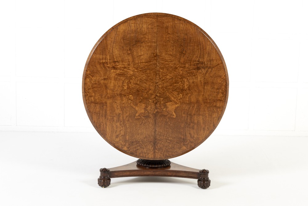 An early nineteenth-century circular centre table featuring a figured burr oak top mounted on a carved central column and a tri-form base with carved feet. View IX