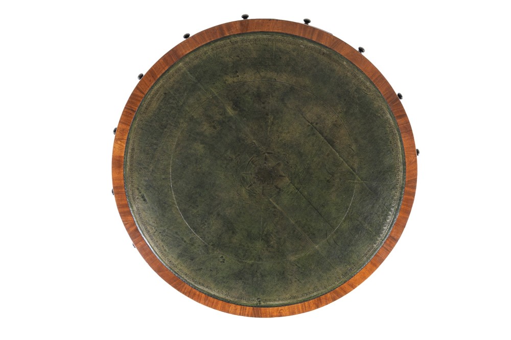A large 19th-century circular mahogany drum table featuring a green leather top, frieze drawers around the apron, and a central pedestal resting on four splayed legs with brass castors. View II