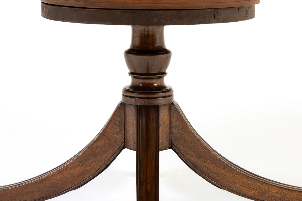 A large 19th-century circular mahogany drum table featuring a green leather top, frieze drawers around the apron, and a central pedestal resting on four splayed legs with brass castors. View V