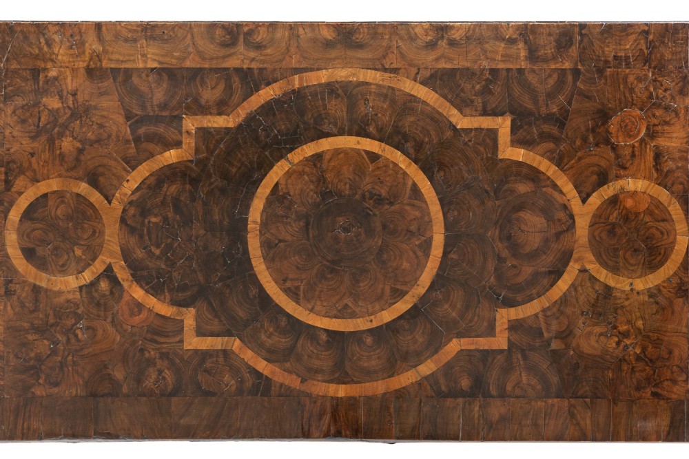 A late 17th-century Dutch walnut chest of drawers featuring geometric oyster veneering, brass drop handles, keyhole escutcheons, and large turned bun feet. View V