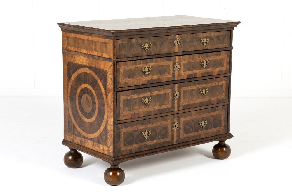 A late 17th-century Dutch walnut chest of drawers featuring geometric oyster veneering, brass drop handles, keyhole escutcheons, and large turned bun feet. View VIII