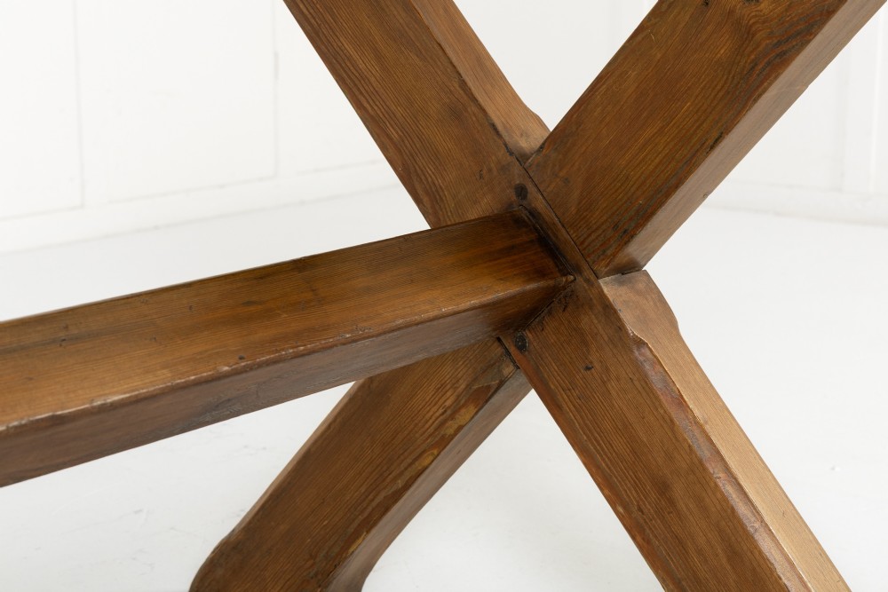 An English pine refectory dining table featuring a rectangular plank top resting on an X-frame trestle base with a central stretcher. View V